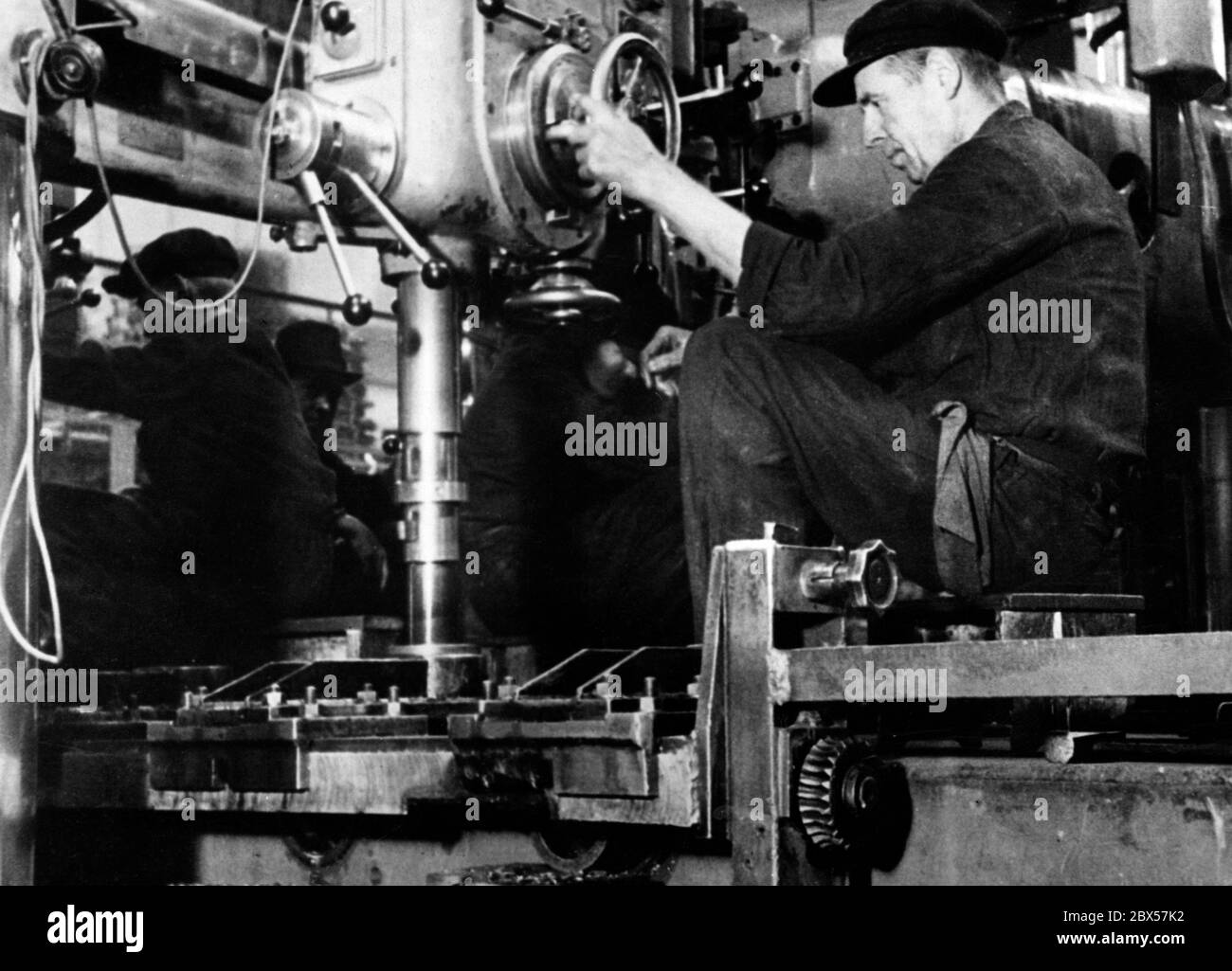 Un lavoratore nell'industria degli armamenti aziona una macchina. Foto Stock