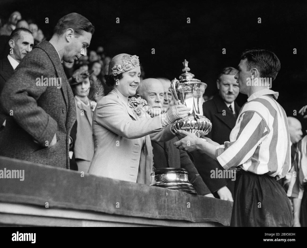 La regina Elisabetta presenta la Coppa dell'Associazione di Calcio al capitano della Sunderland H. carter dopo che la sua squadra ha bato Preston North a 3-1 nella finale al Wembley Stadium. Accanto a lei c'è il Re Giorgio VI. Foto Stock