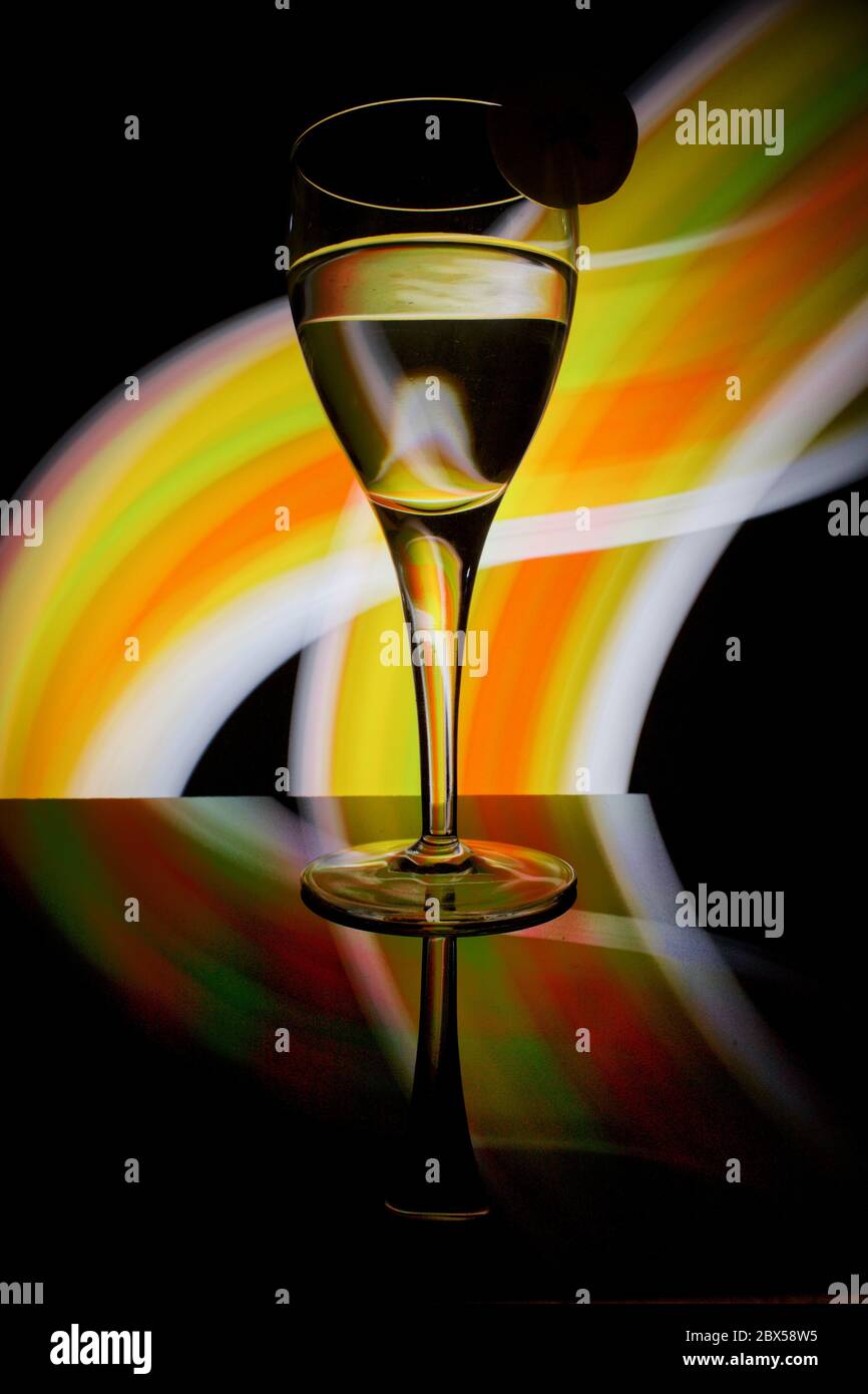 Bella pittura di luce con vetro dell'acqua su sfondo nero Foto Stock