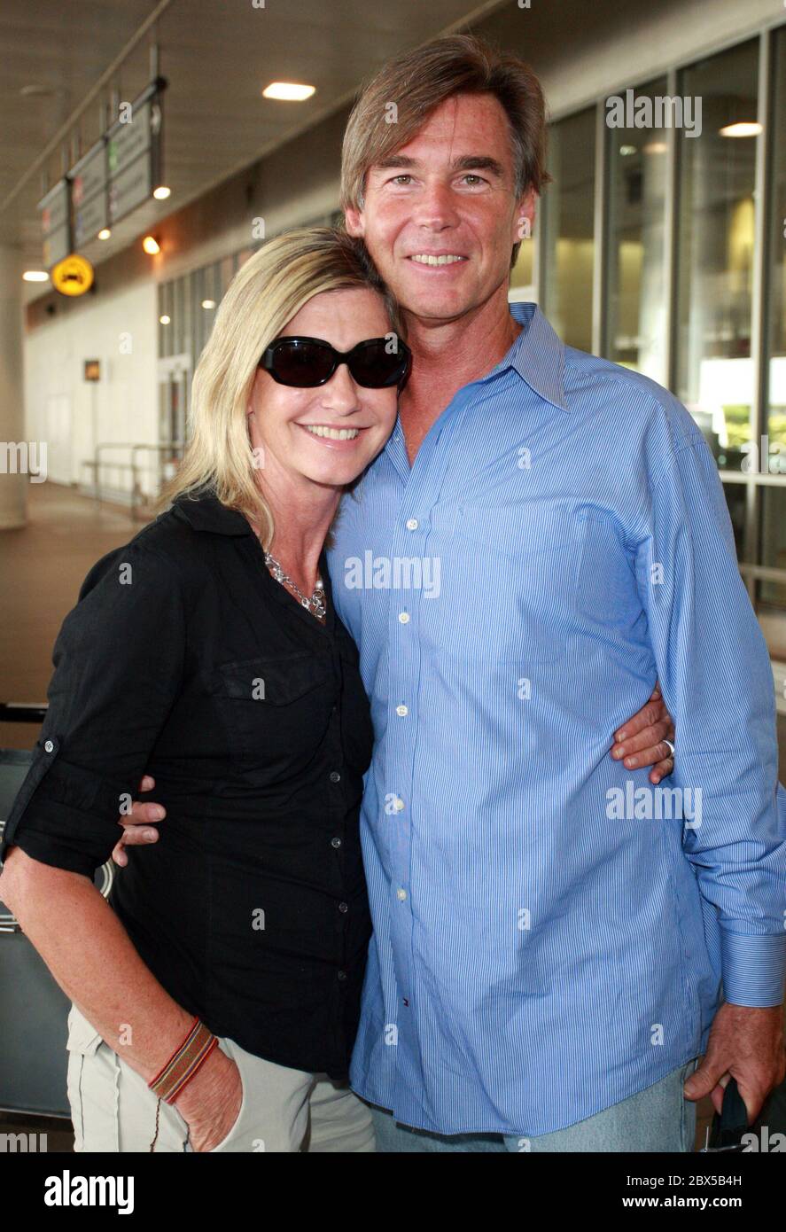 Olivia Newton-John e il marito arrivano all'aeroporto LAX dopo una breve vacanza in Florida. Olivia era incandescente e sorride mentre si recava a casa. Agosto 14 2008 Foto Stock