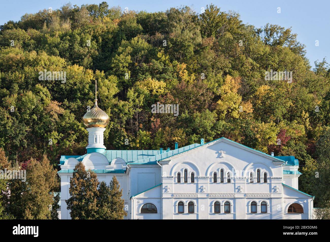 Edifici Sviatohirsk Lavra sullo sfondo di una piccola collina, coperta di vegetazione lussureggiante. L'autunno si avvicina Foto Stock