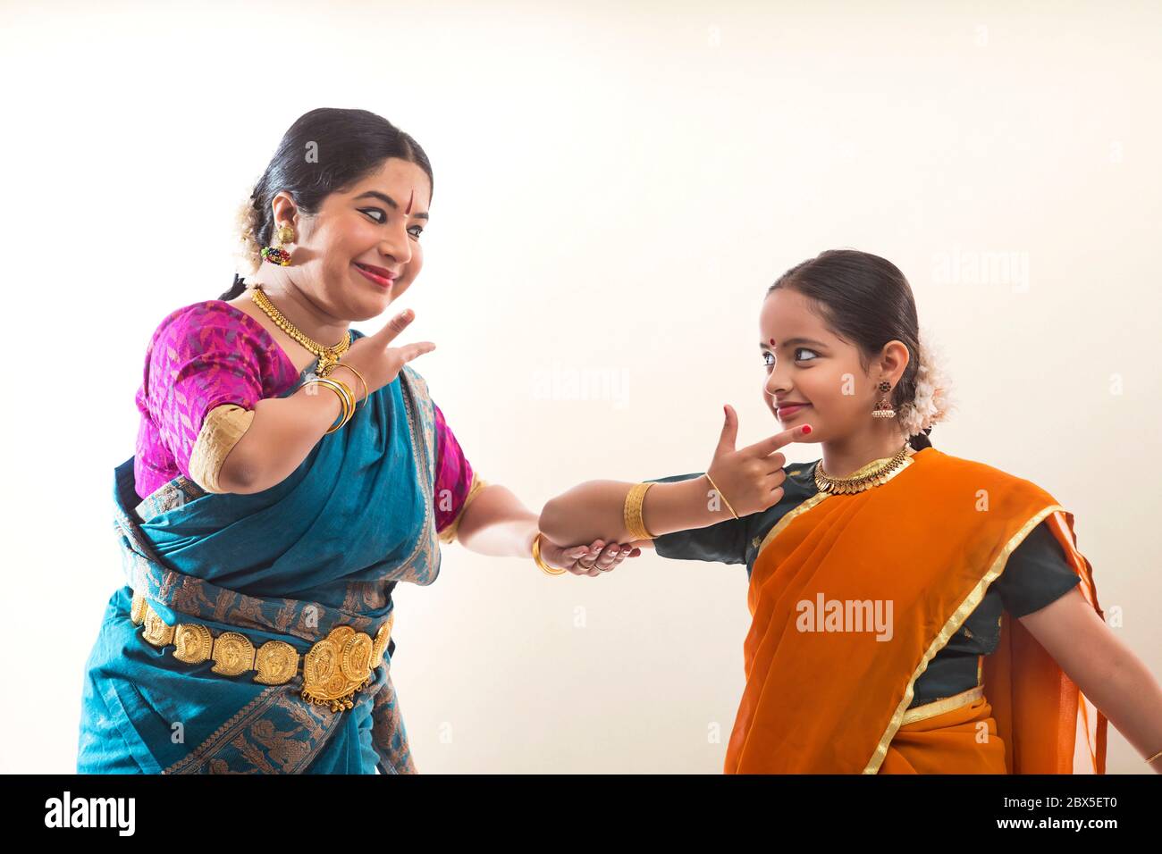 Giovane bharatnatyam ballerina imparando mudra ed espressioni dal suo insegnante. Foto Stock