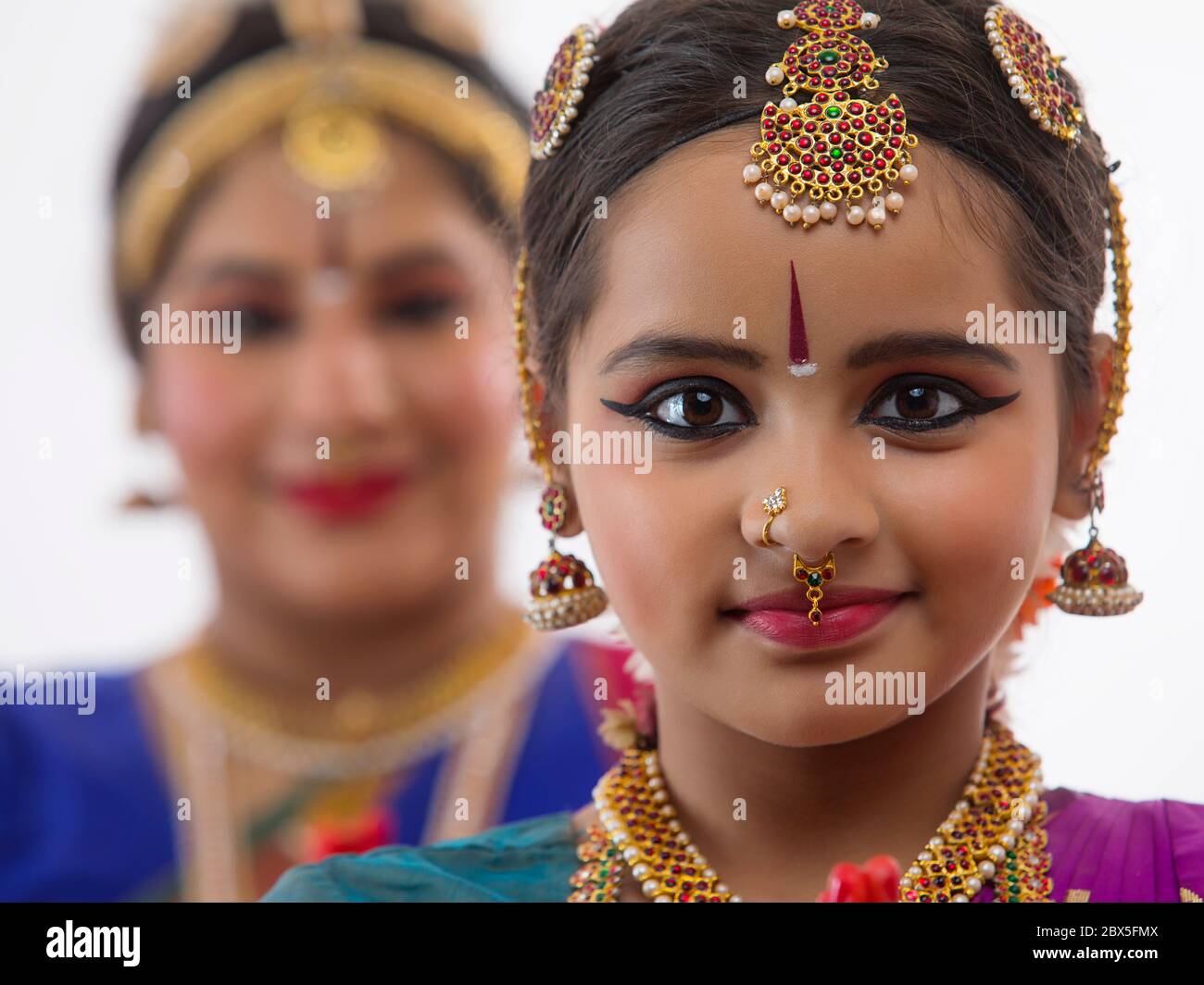 Giovane bharatnatyam ballerina in piedi davanti al suo insegnante con le mani piegate. Foto Stock
