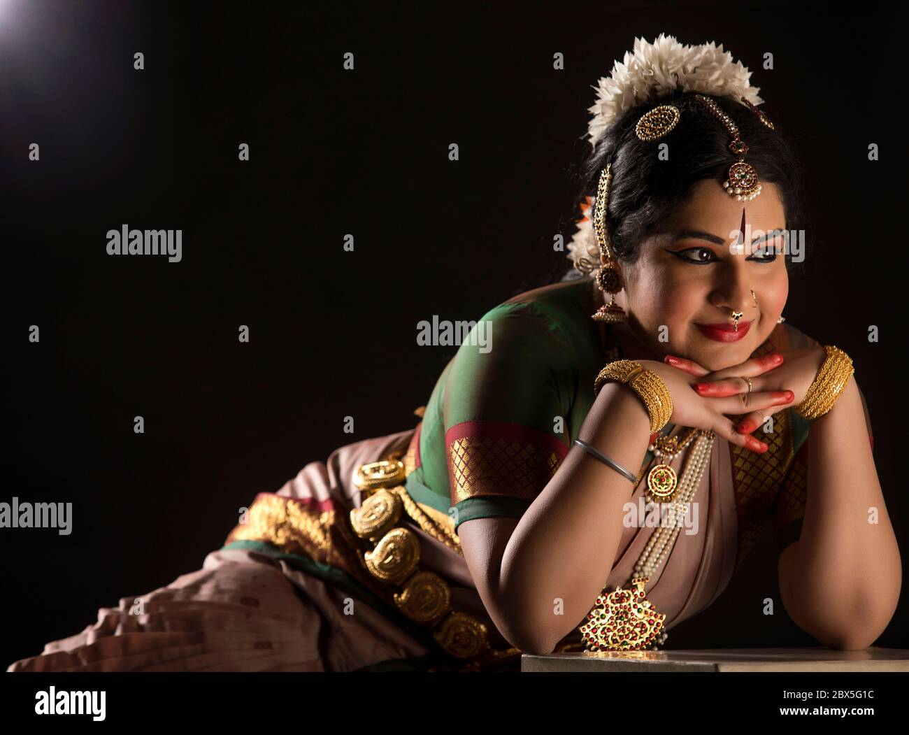 Ballerina Bharatnatyam seduta con grazia durante la sua esecuzione. Foto Stock