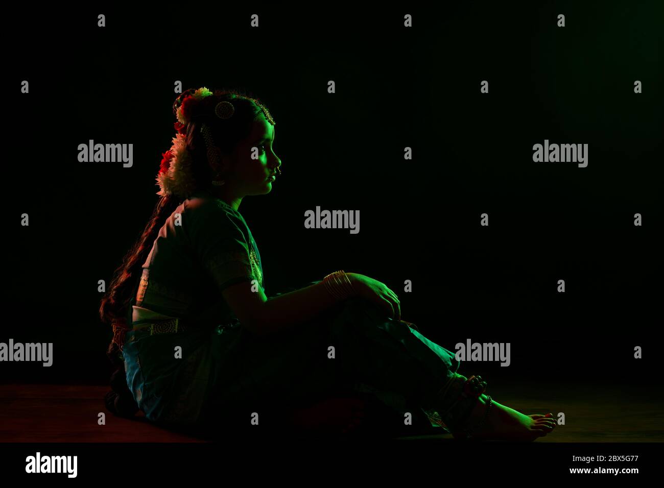 Giovane ballerina bharatnatyam seduto sul palco durante una performance. Foto Stock