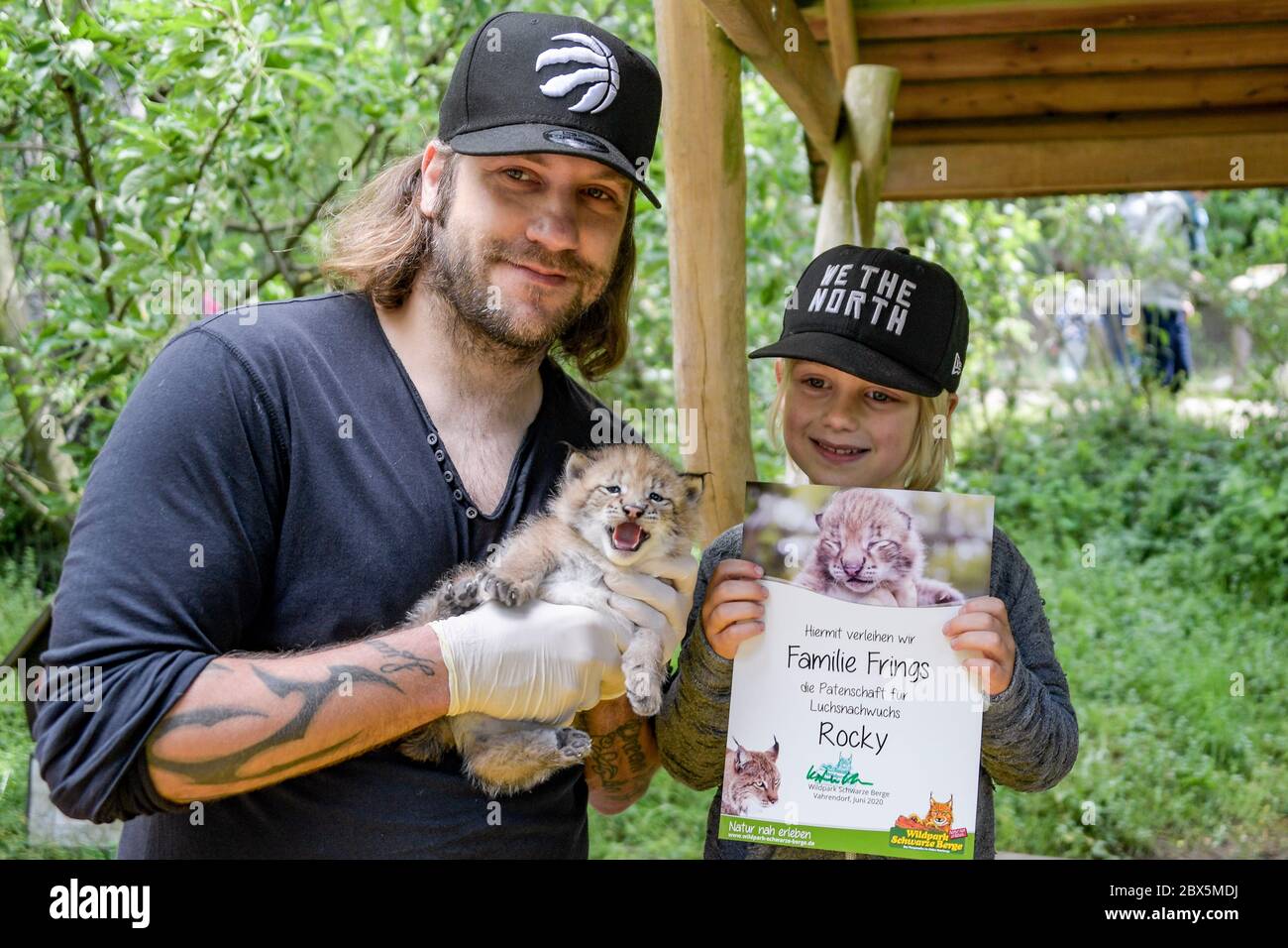 Amburgo, Germania. 05 giugno 2020. Torsten Frings (l), ex calciatore e padrino lynx, e Frings figlio Luke stanno tenendo una delle tre lynxes neonati nelle loro braccia. Dopo un esame iniziale da parte del veterinario, uno degli animali nel Black Mountains Game Park è stato battezzato 'Rocky'. Credit: Axel Heimken/dpa/Alamy Live News Foto Stock