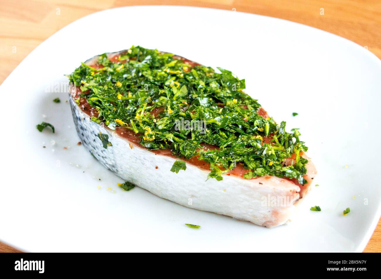 Salmone crudo con sale, pepe ed erbe. Pesce rosso in marinata. Foto Stock