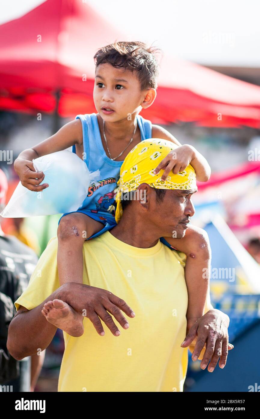 Un padre filippino gode di una giornata con suo figlio mentre guardano la Festa del Festival del Nazareno Nero a Manila, Filippine, gennaio 2020. Foto Stock