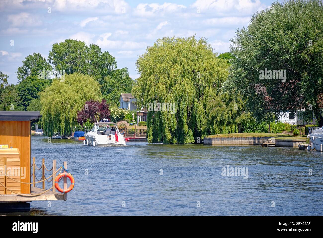 Il Tamigi a Old Windsor con esclusive case lungo il fiume in una giornata estiva soleggiata, Berkshire Inghilterra UK Foto Stock