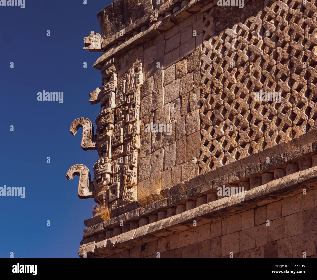Angolo del tempio Maya con sculture in pietra dettagliate che rappresentano gli dei Maya e simboli a Uxmal, Messico Foto Stock