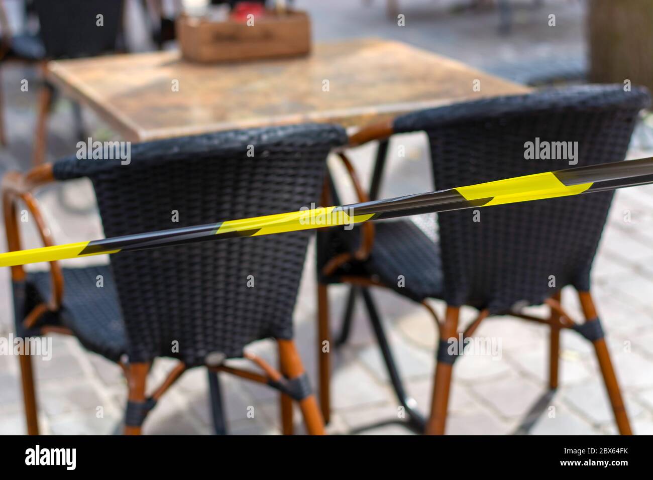 Terrazze in città di nuovo aperto. Il nastro di sicurezza sulla terrazza garantisce la possibilità di mantenere una distanza sociale sicura tra i tavoli e le sedie durante il coronavirus Foto Stock