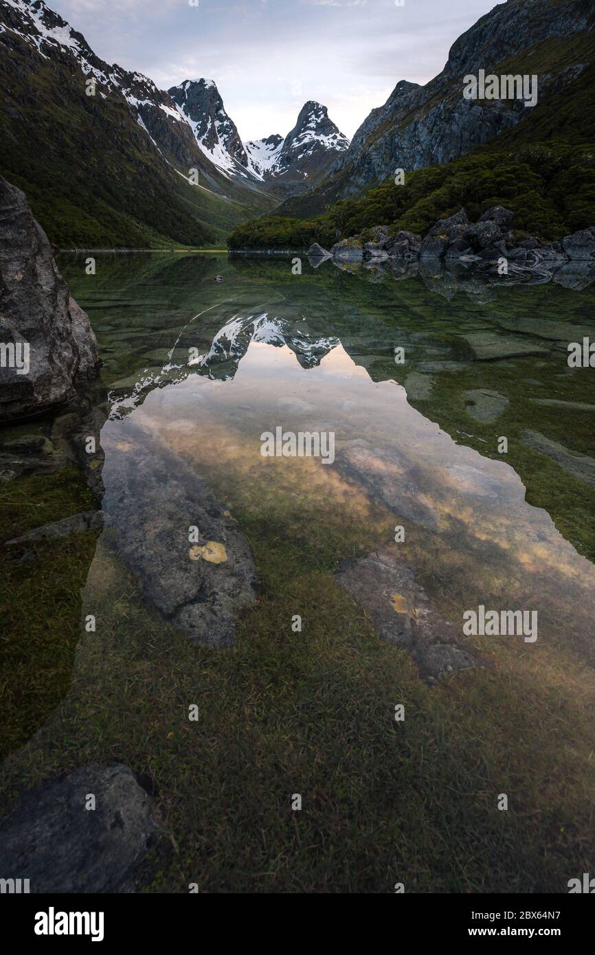 Emily picco che riflette nel lago McKenzie al tramonto, Routeburn traccia, Isola del Sud, Nuova Zelanda Foto Stock