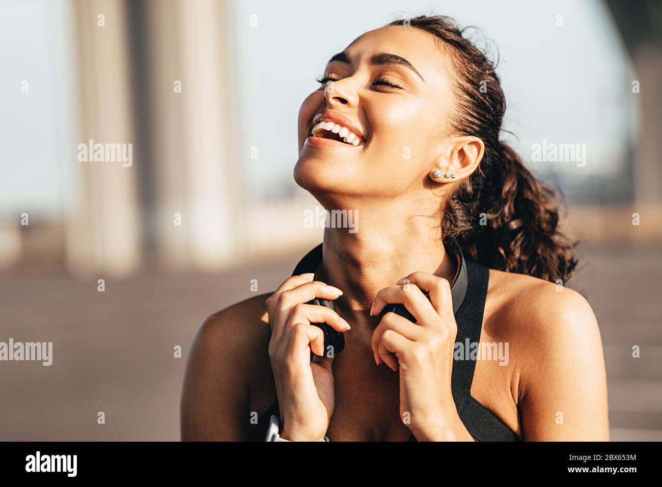 Ragazza felice con le cuffie intorno al collo Foto Stock