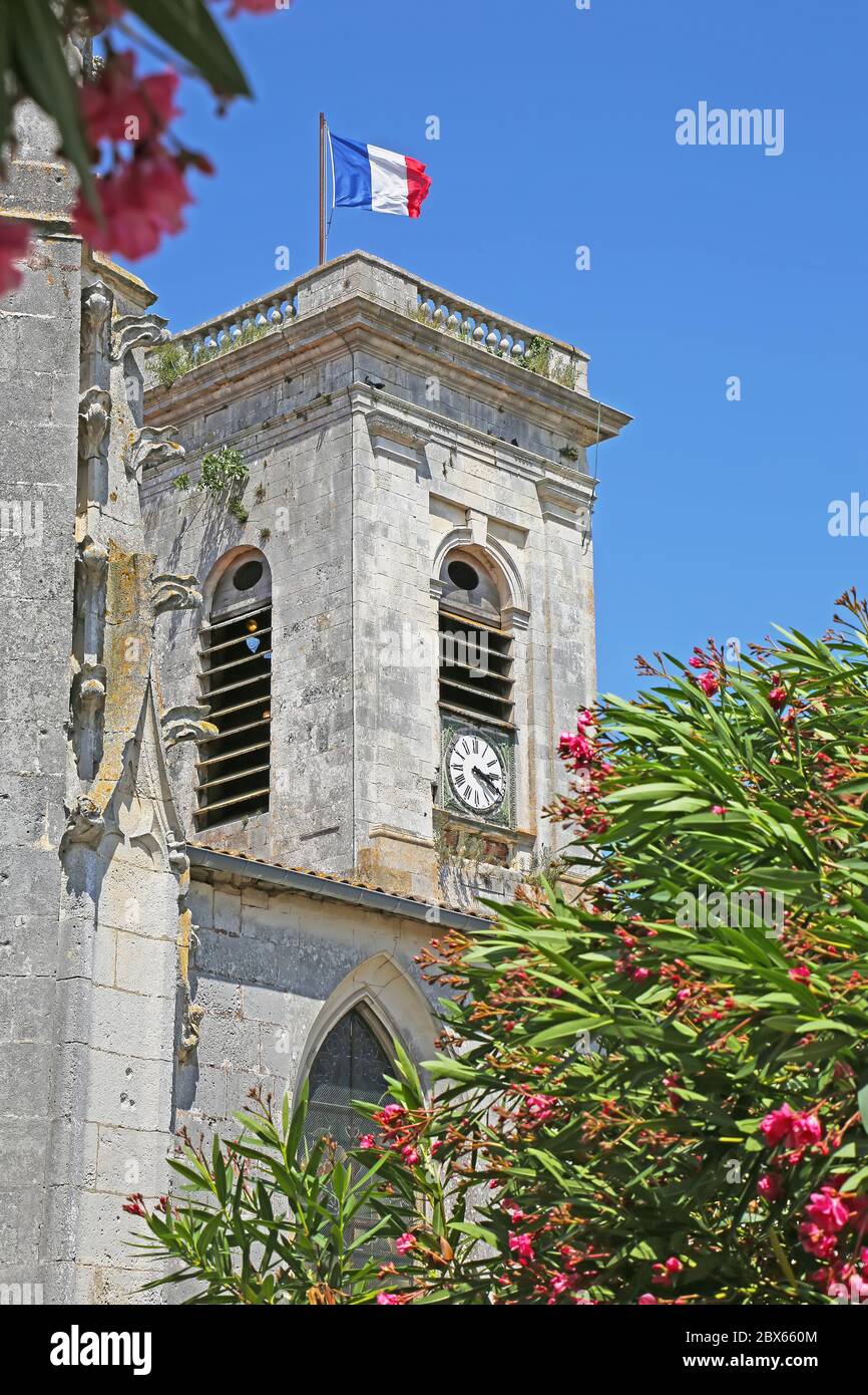 Chiesa cattolica di San Martino de Re con la bandiera francese che vola, isola di Ile de Re, Francia Foto Stock