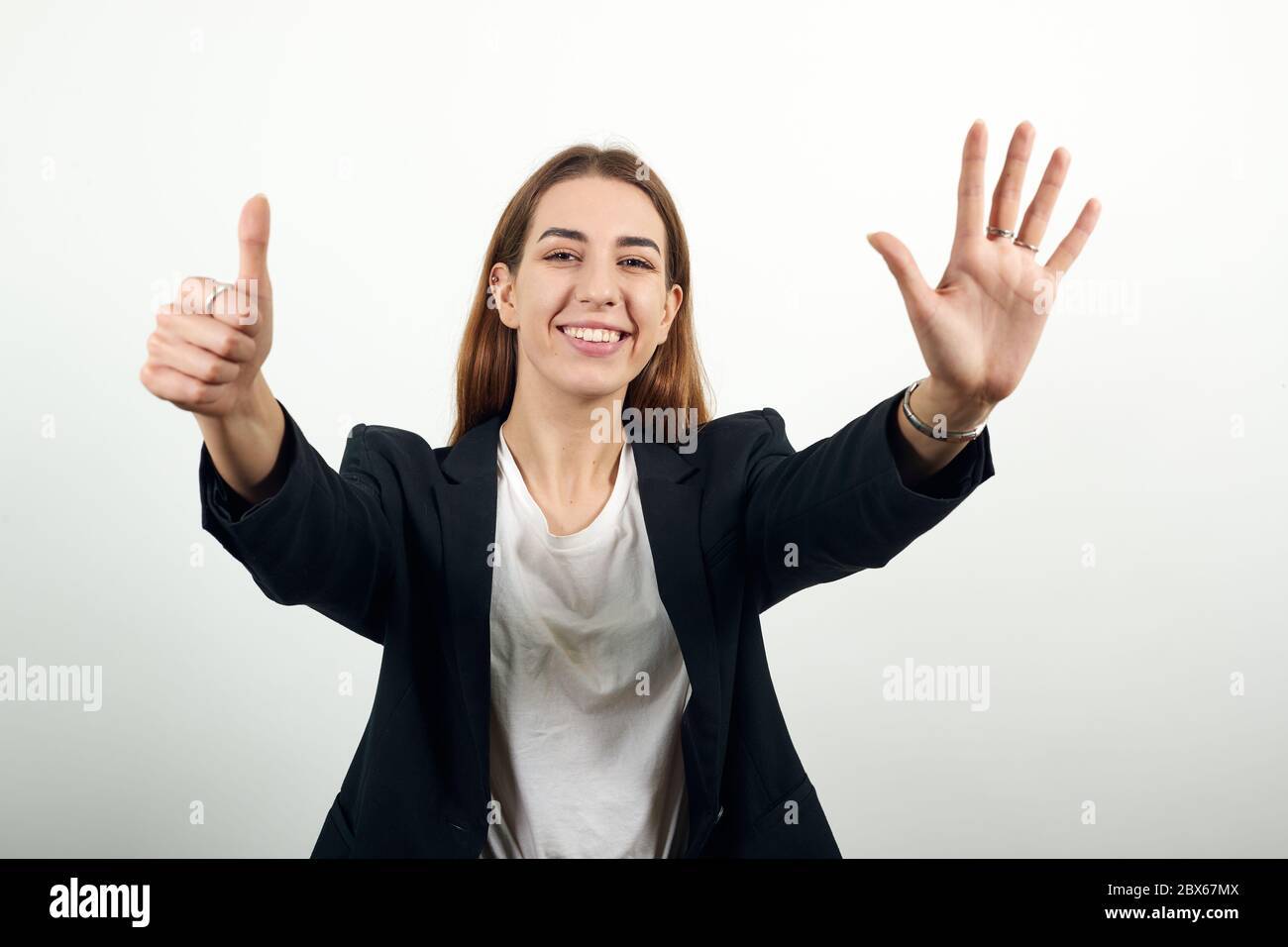 Felice femmina sorride, mostra sei dita sulle mani. Account, azienda, saluto Foto Stock