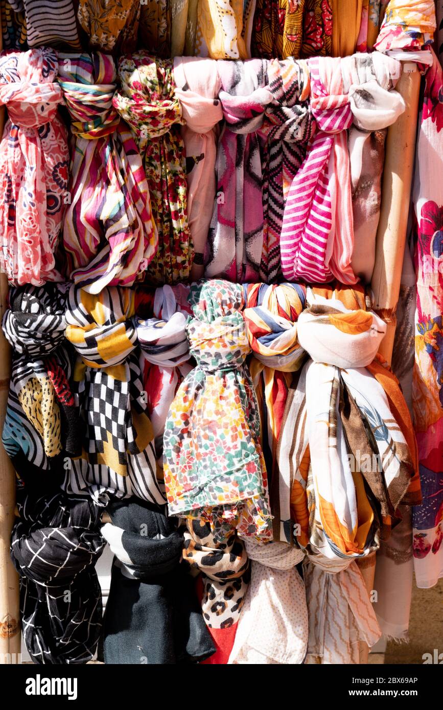 Colorate sciarpe appesi in uno scaffale di un negozio di moda Foto stock -  Alamy