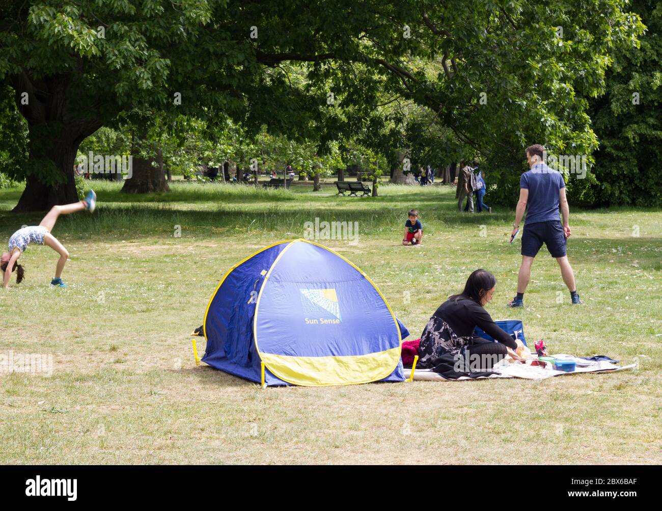 La famiglia gode del sole a Greenwich Park in una giornata di sole durante la pandemia di Covid-19 per una guida di esercizio di un giorno in Inghilterra, Regno Unito Foto Stock