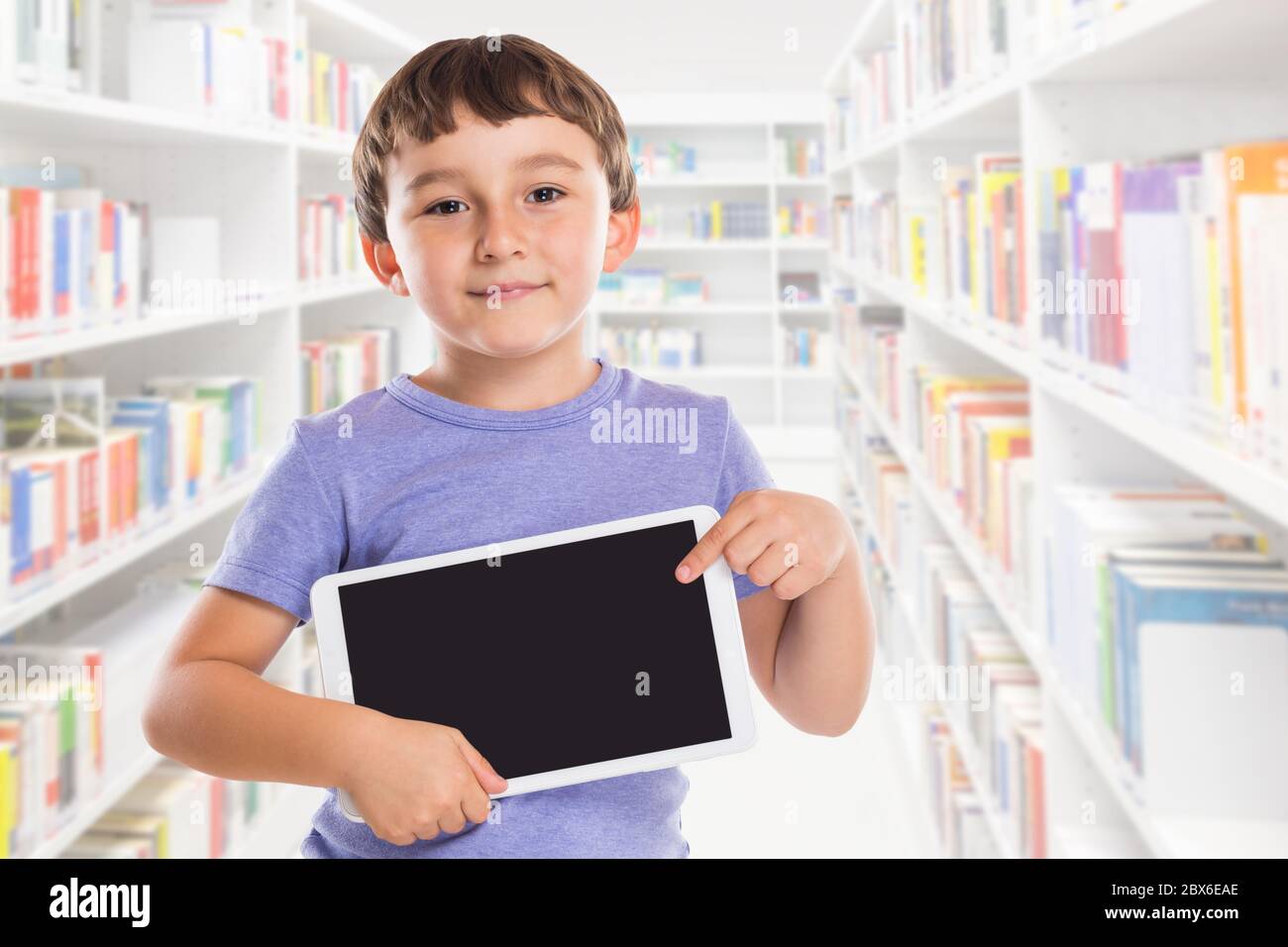 Bambino giovane che punta al calcolatore della tavoletta la biblioteca di informazioni di vendita ad imparare la pubblicità Foto Stock
