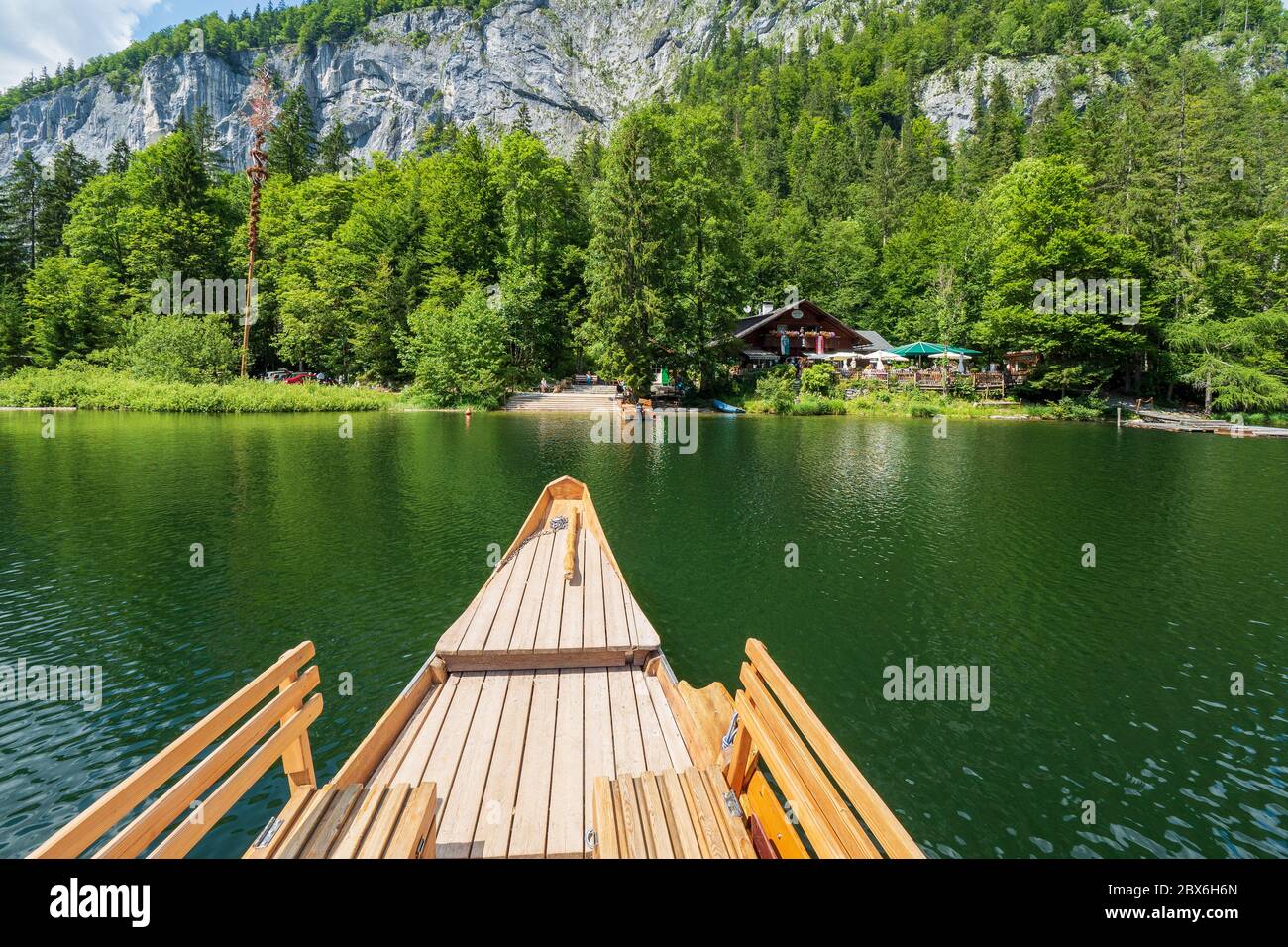 Una 'Plätte', una tradizionale barca piatta, che si avvicina al ristorante 'Fischerhütte' presso il leggendario Lago Toplitz, regione Ausseer Land, Stiria, Austria Foto Stock