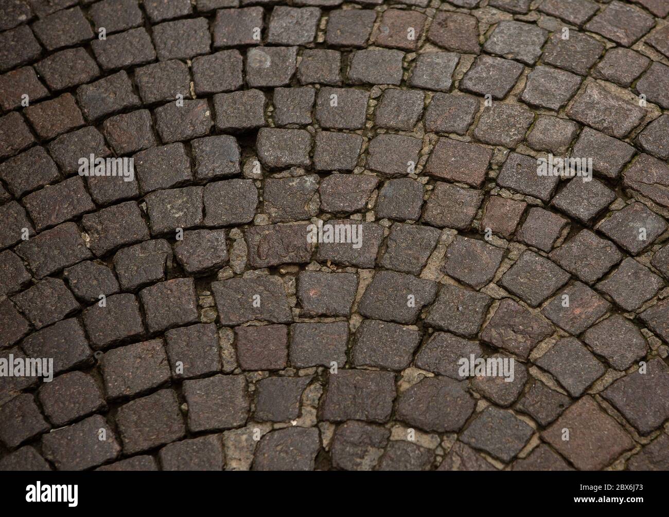 Lapide di un muro o di una strada. Pietre marroni piegate in un semicerchio. Primo piano. Trama astratta o sfondo Foto Stock