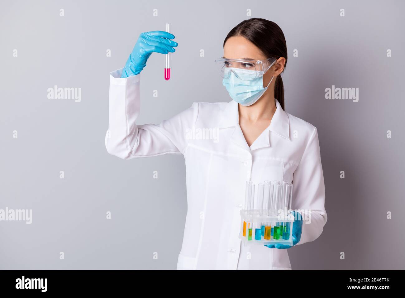 Foto di virologo doc lady esperto professionista tenere provette per matracci confrontare risultati della sonda di vaccino indossare guanti maschera facciale occhiali protettivi Foto Stock