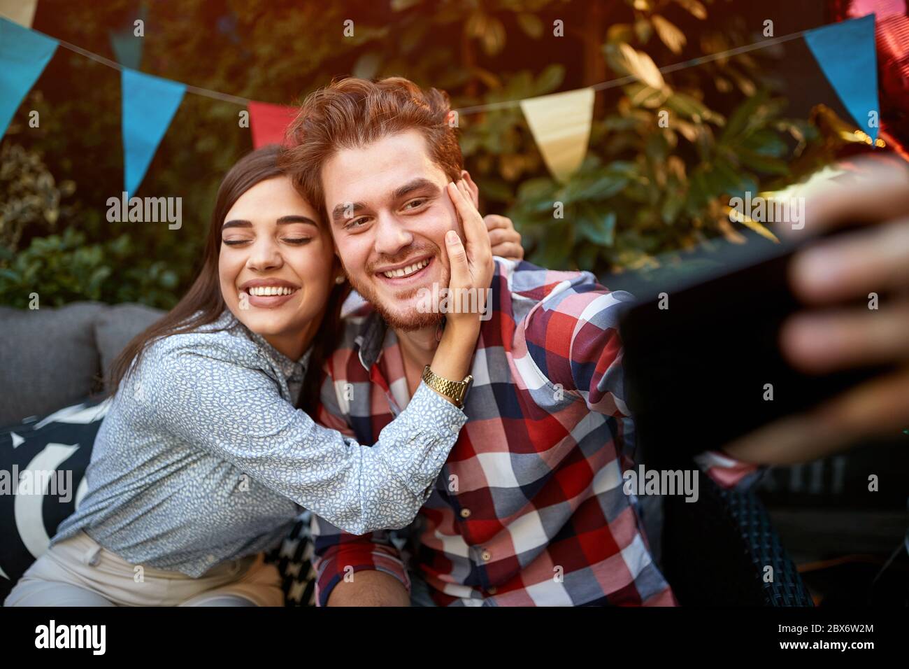 Ragazza con ragazzo in festa di b-day facendo selfie insieme Foto Stock