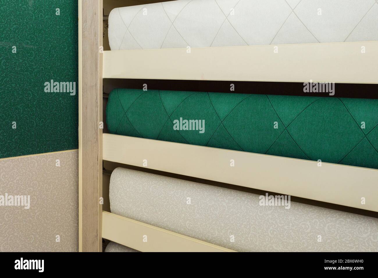 Scaffalatura nel negozio. Elegante multicolore con rotoli dal design moderno. Sfondi di lusso per interni. Foto Stock