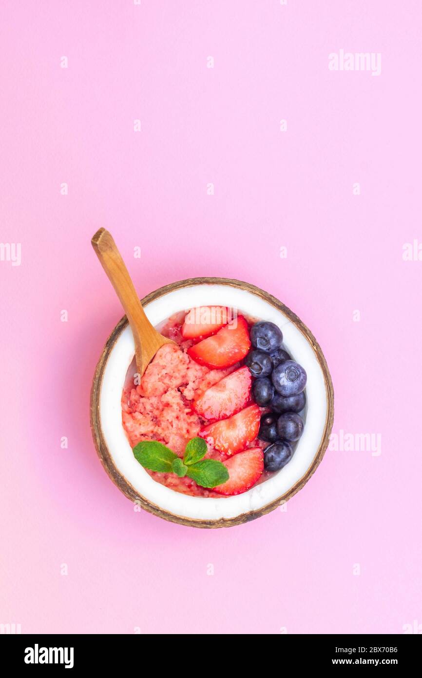 Frullato sano per la colazione con frutti di bosco freschi su sfondo rosa pastello Foto Stock