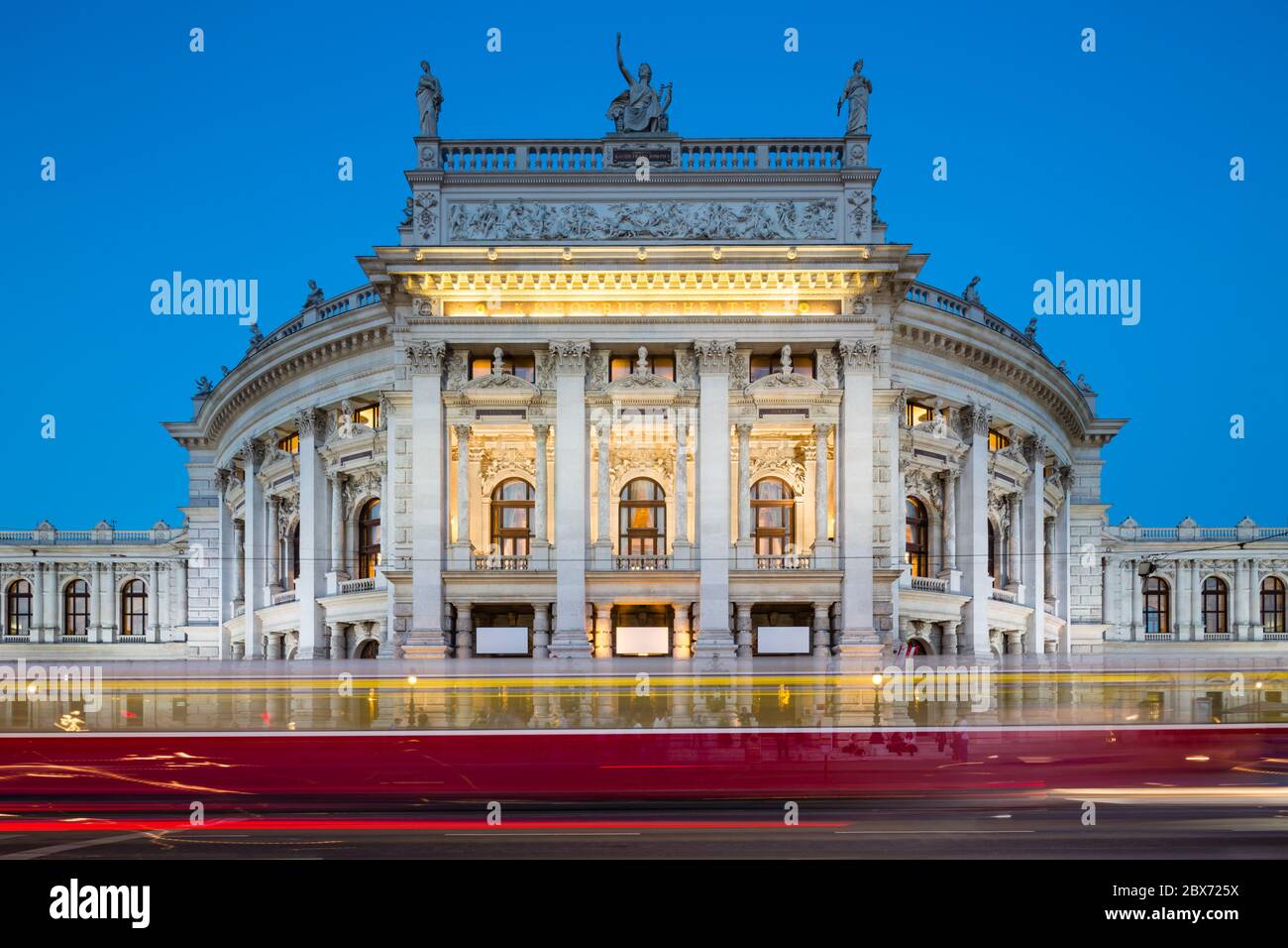 Vista del Burgtheater di Vienna, in Austria di notte con un tram che passa Foto Stock