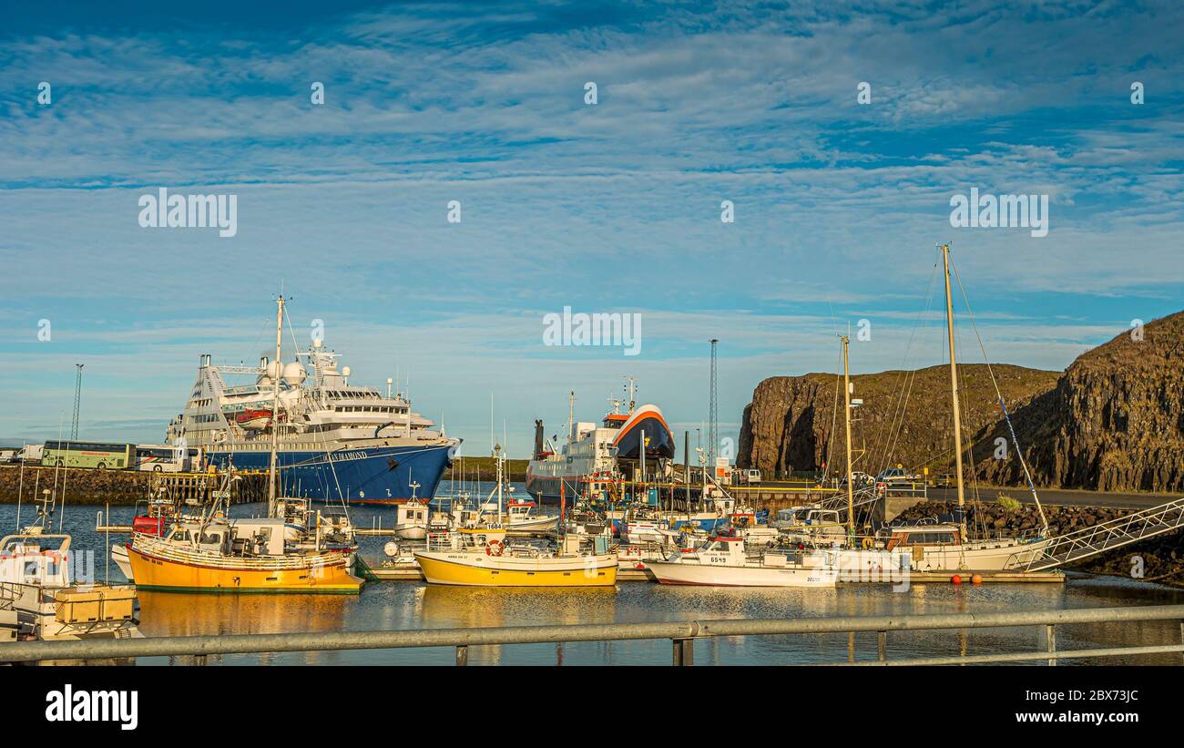 Vista panoramica sul tramonto al centro di Stykisholmur (Stykkish) e al porto con molti ristoranti di pesce, yacht, barche e un traghetto verso la parte occidentale del F. Foto Stock