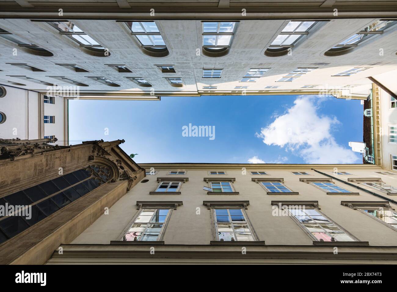 Vista straigt up con edifici intorno a uno dei piccoli cortili interni dell'Hofburg a Vienna, Austria con cielo blu. Foto Stock