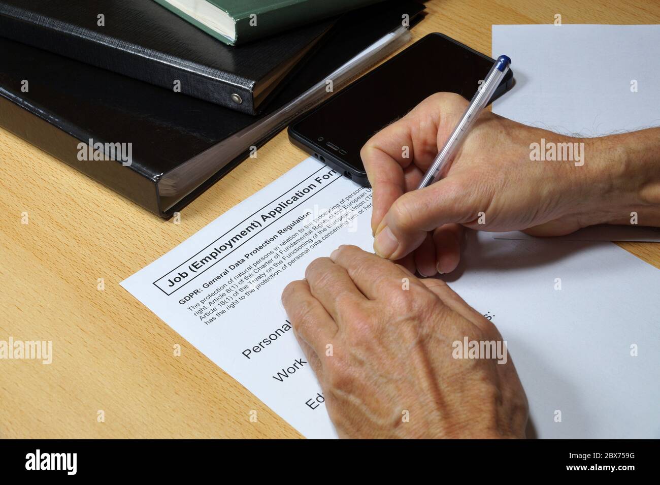 Importanti cambiamenti di legge. Un uomo che compila il modulo di assunzione con la clausola del regolamento generale sulla protezione dei dati (GDPR). Foto Stock