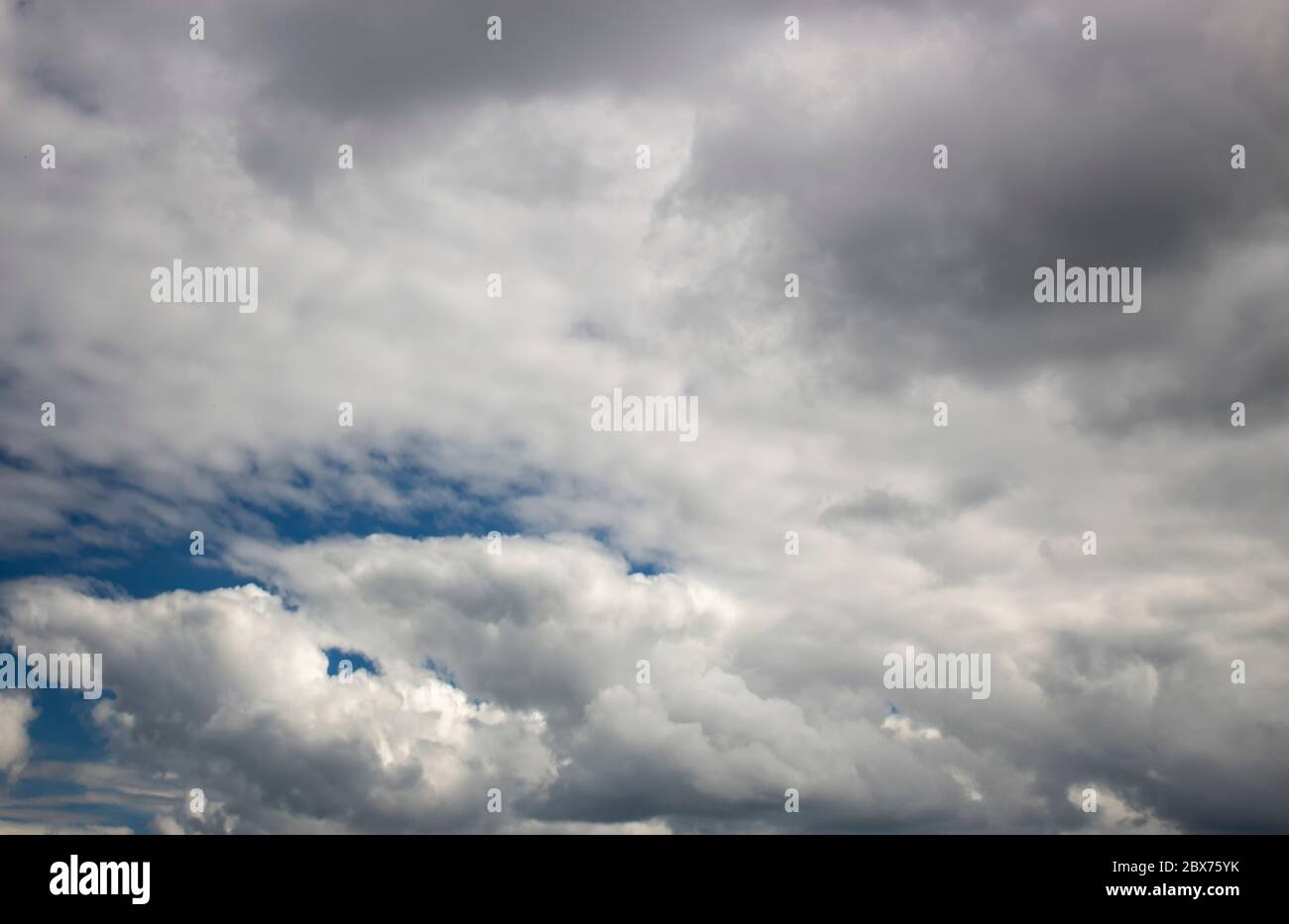 Nuvole parzialmente nuvole, scure che si raccolgono in fitte nuvole tempesta. Foto Stock