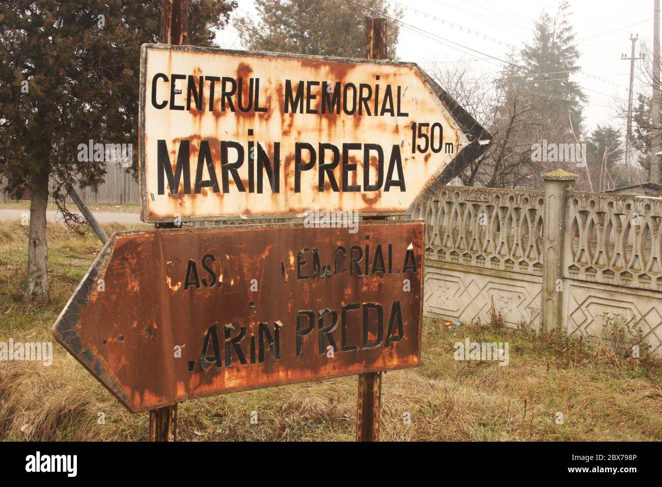 Silistea Gumesti, Romania. Indicatori in cattiva forma verso due centri commemorativi per lo scrittore romeno Marin Preda. Foto Stock