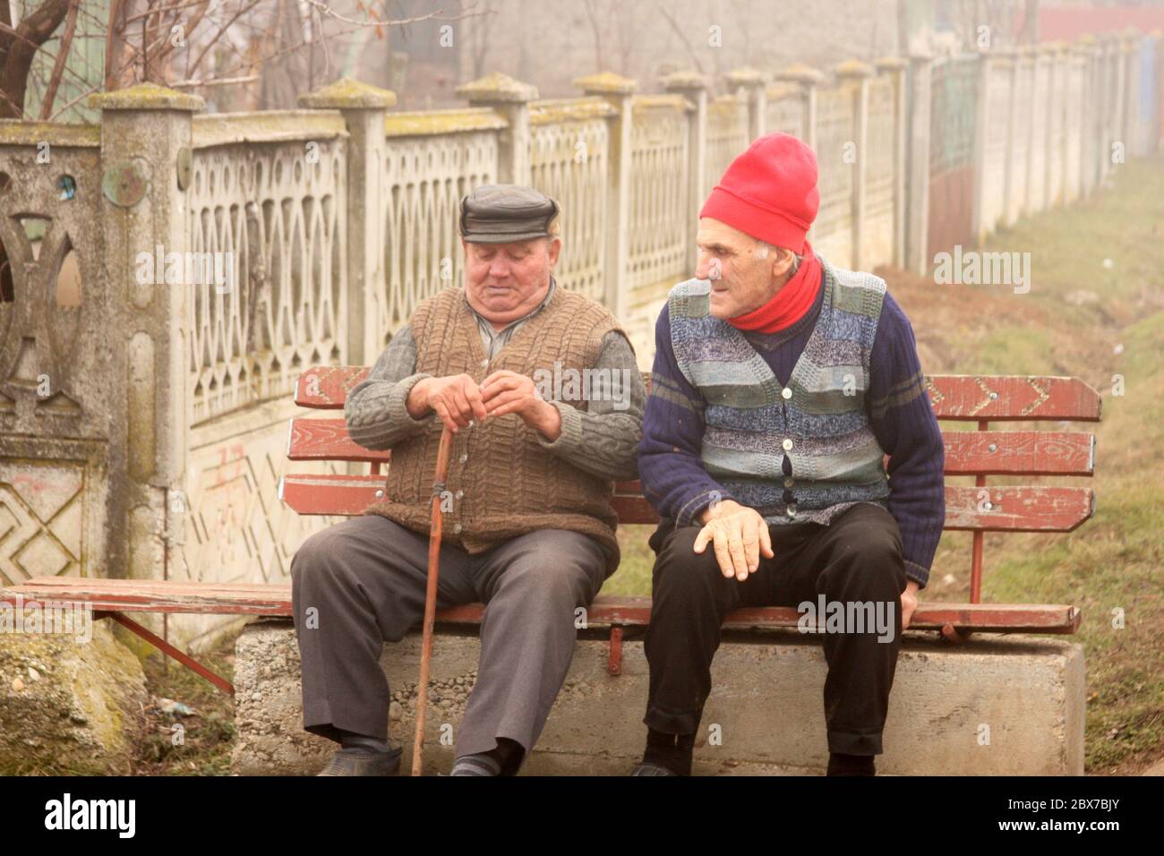 Silistea Gumesti, Romania. Due anziani locali su una panchina esterna. Foto Stock
