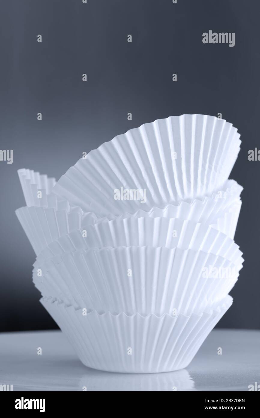 Pila di contenitori vuoti per cupcake su sfondo tonato. Foto Stock