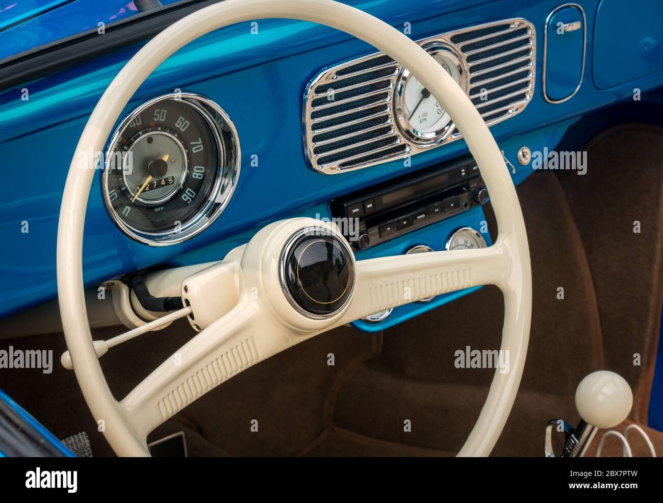 Parte dell'interno della vecchia macchina con timer blu con volante, tachimetro, quadranti del regime, pannello anteriore Foto Stock