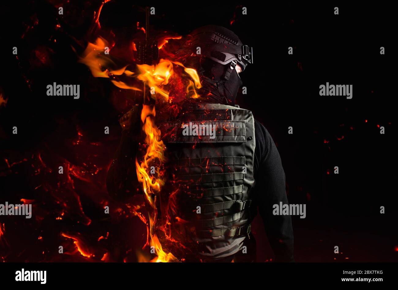 Foto di un soldato`s indietro con effetto fiamma su sfondo nero. Foto Stock