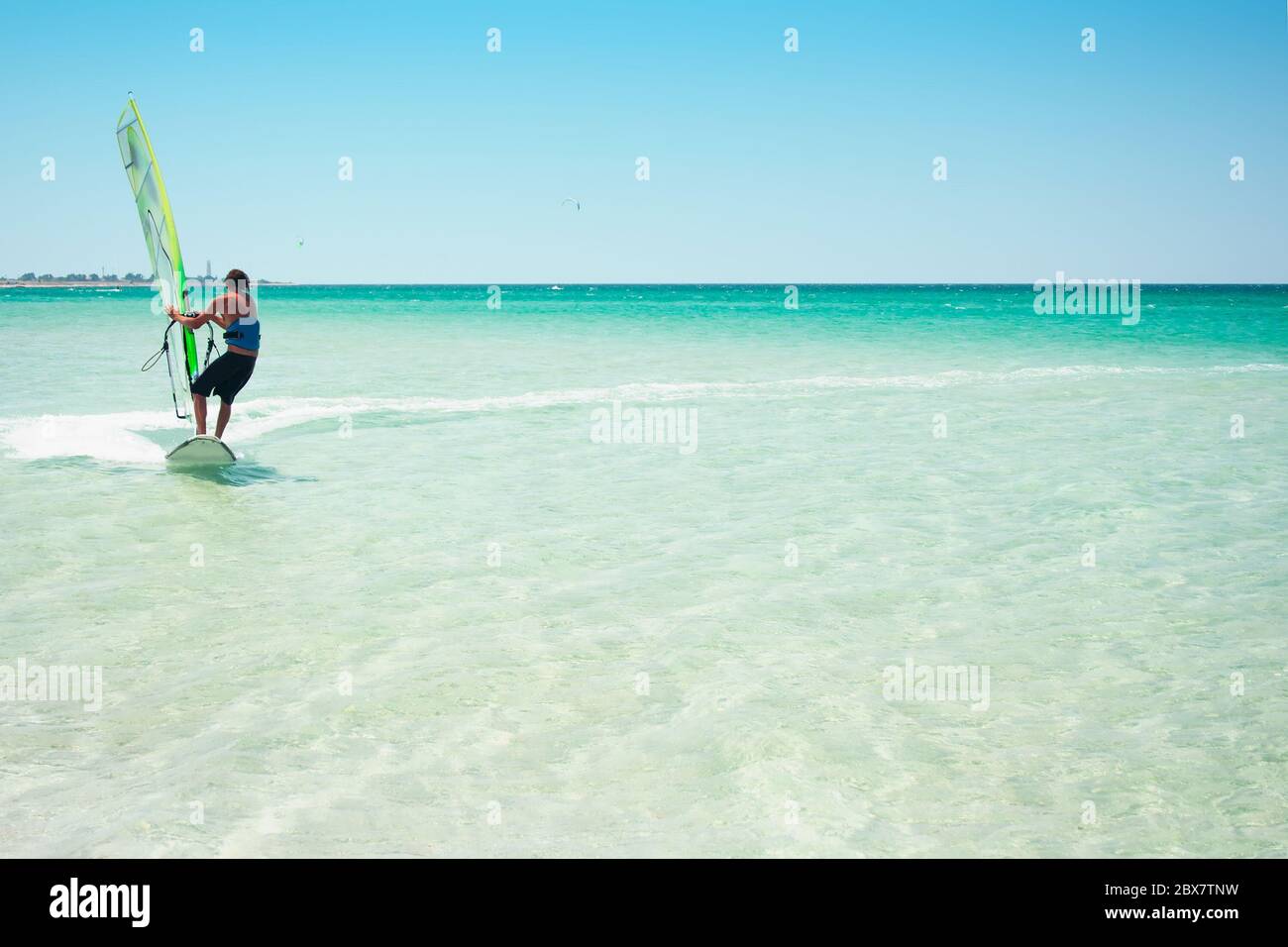 Olenevka, Ucraina-11 agosto 2013: Uomo windsurf che si esercita su un mare turchese blu. Foto Stock