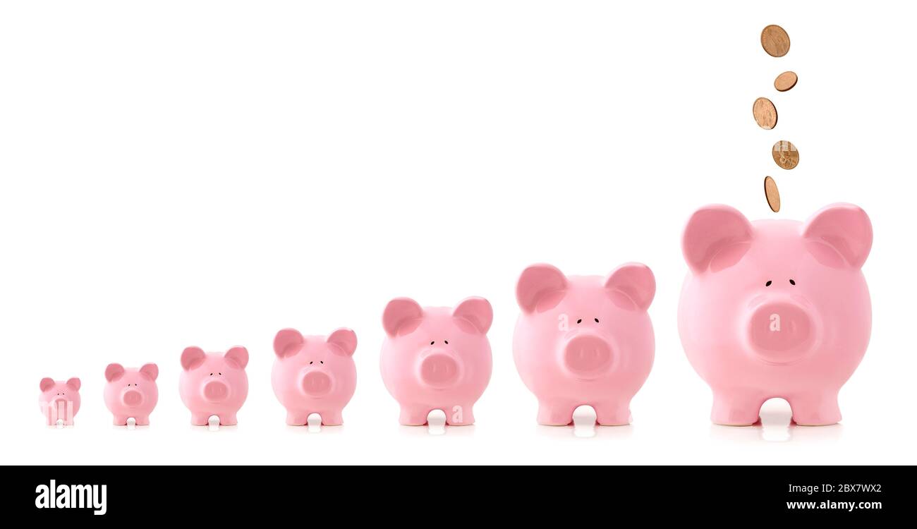 Le banche piggy rosa aumentano di dimensioni, con monete che cadono in più grandi. Concetto di investimento in crescita. Foto Stock