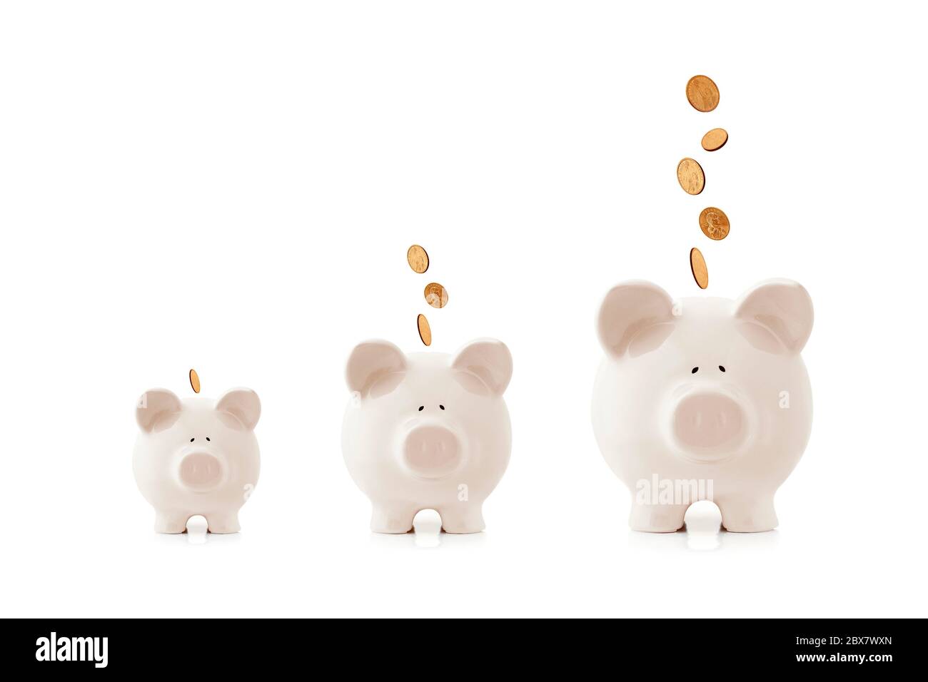 Le banche piggy aumentano di dimensioni, con le monete che cadono in loro. Concetto di investimento in crescita. Foto Stock