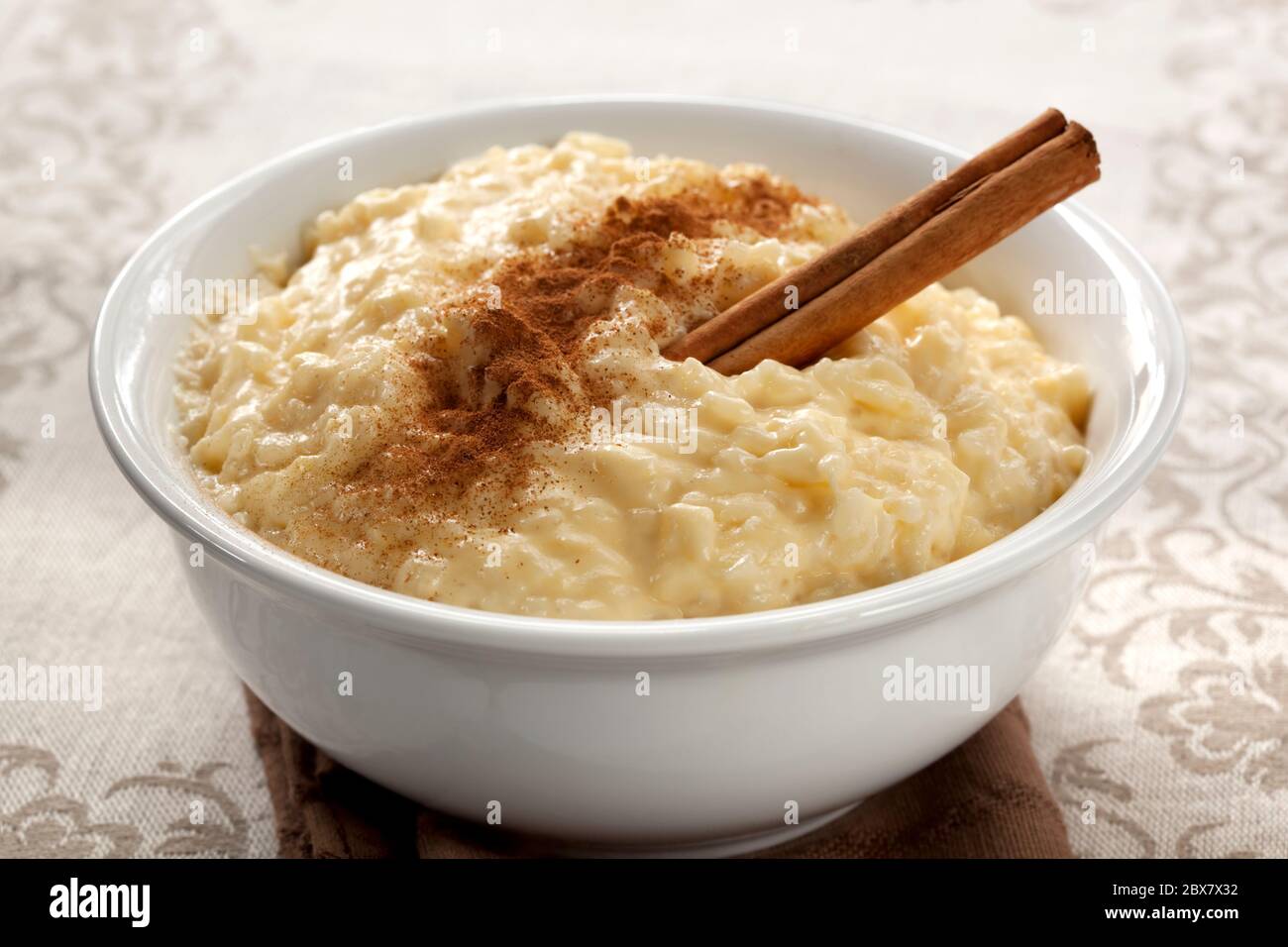 Budino di riso cremoso con cannella. Un semplice e nutriente dessert a base di riso, latte, uova, vaniglia e zucchero. Foto Stock