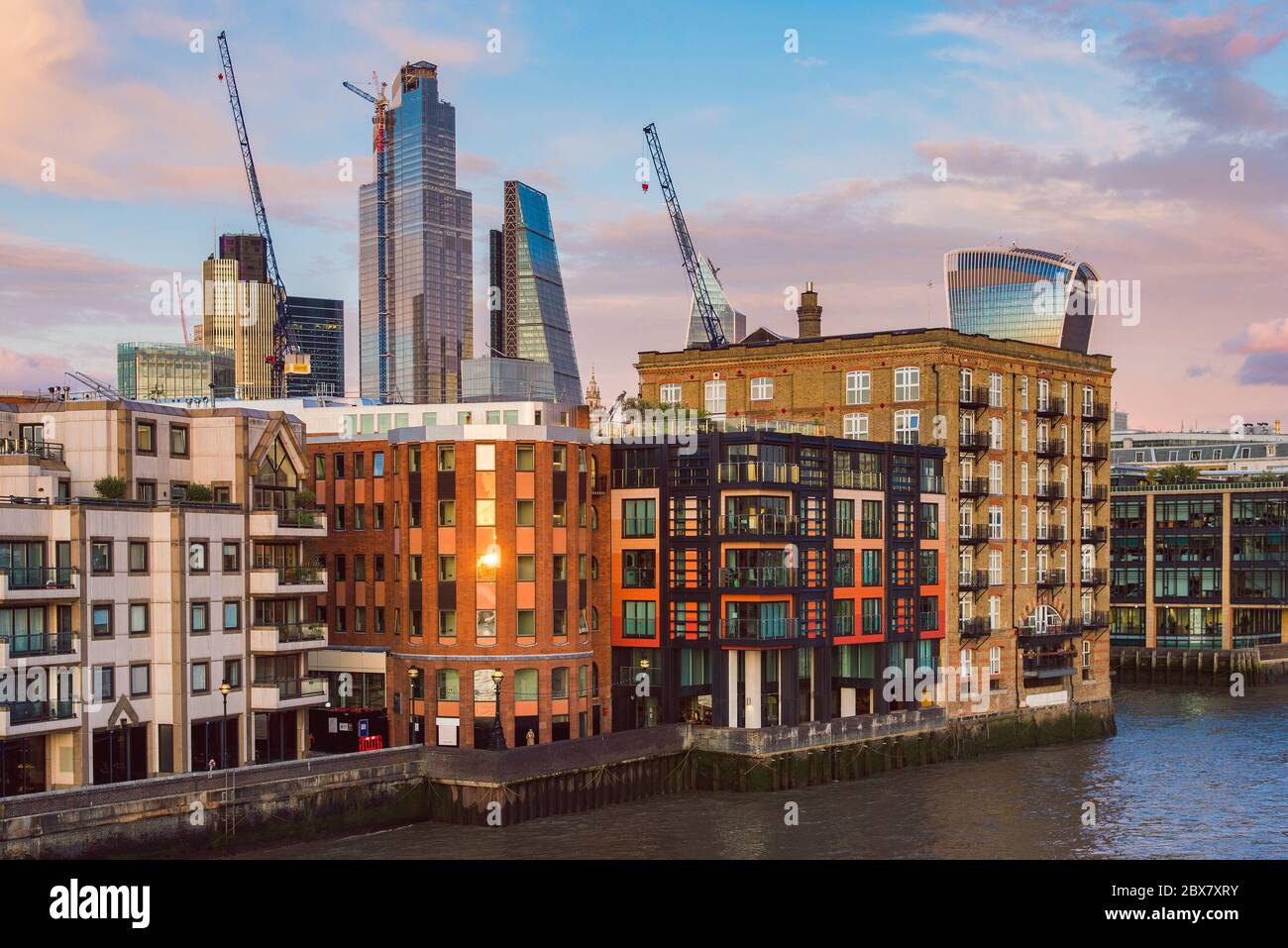 Edifici residenziali di fronte al Tamigi e moderni grattacieli della City di Londra Foto Stock