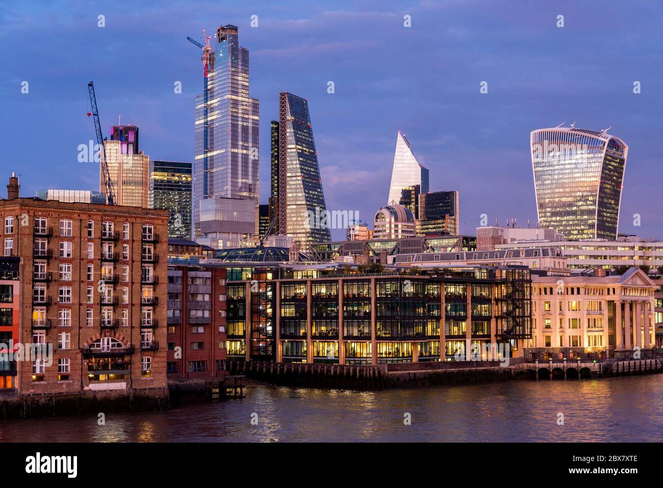 Edifici residenziali di fronte al Tamigi e moderni grattacieli della City di Londra Foto Stock