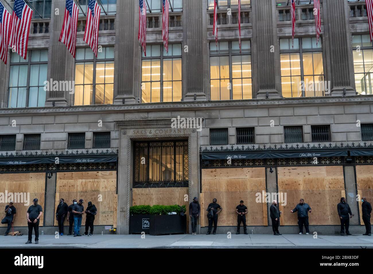 NEW YORK, NY - GIUGNO 03: La famosa Saks Fifth Avenue prepara per più saccheggio con la catena di collegamento recinzione sopra le finestre a bordo e le guardie di sicurezza e d Foto Stock