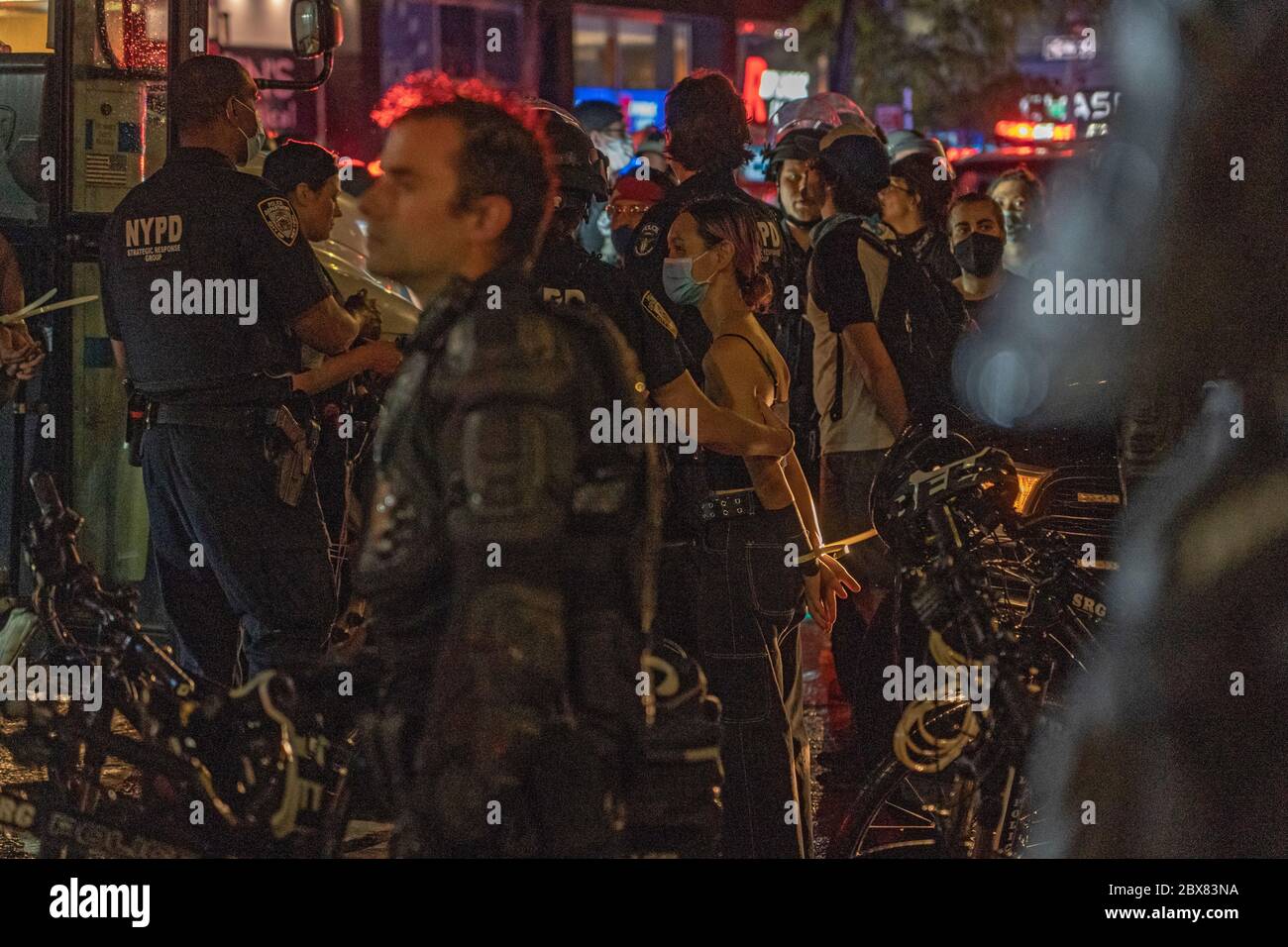 NEW YORK, NY - GIUGNO 03: I manifestanti in manichetta sono allineati e procedono prima di essere condotti su un autobus di correzione sulla scena di un arresto di massa di protesta Foto Stock