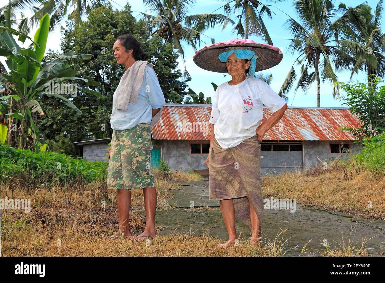 Due Signore balinesi. Uno con un sarong e un cappello conico. Vicino a Ubud, Bali, Indonesia. Foto Stock