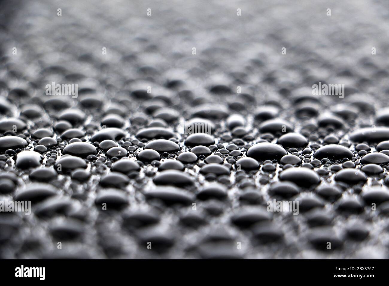 Primo piano di migliaia di gocce d'acqua con perline sul veicolo Foto Stock