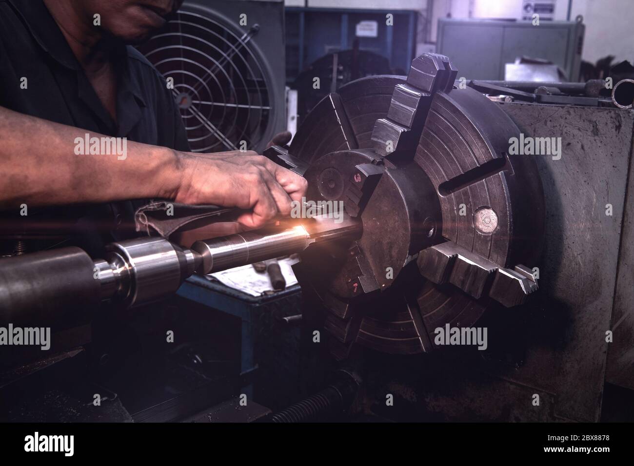 I lavoratori professionisti stanno svolgendo il processo di fresatura per parti metalliche, macchinari metallici in grandi impianti industriali. Foto Stock