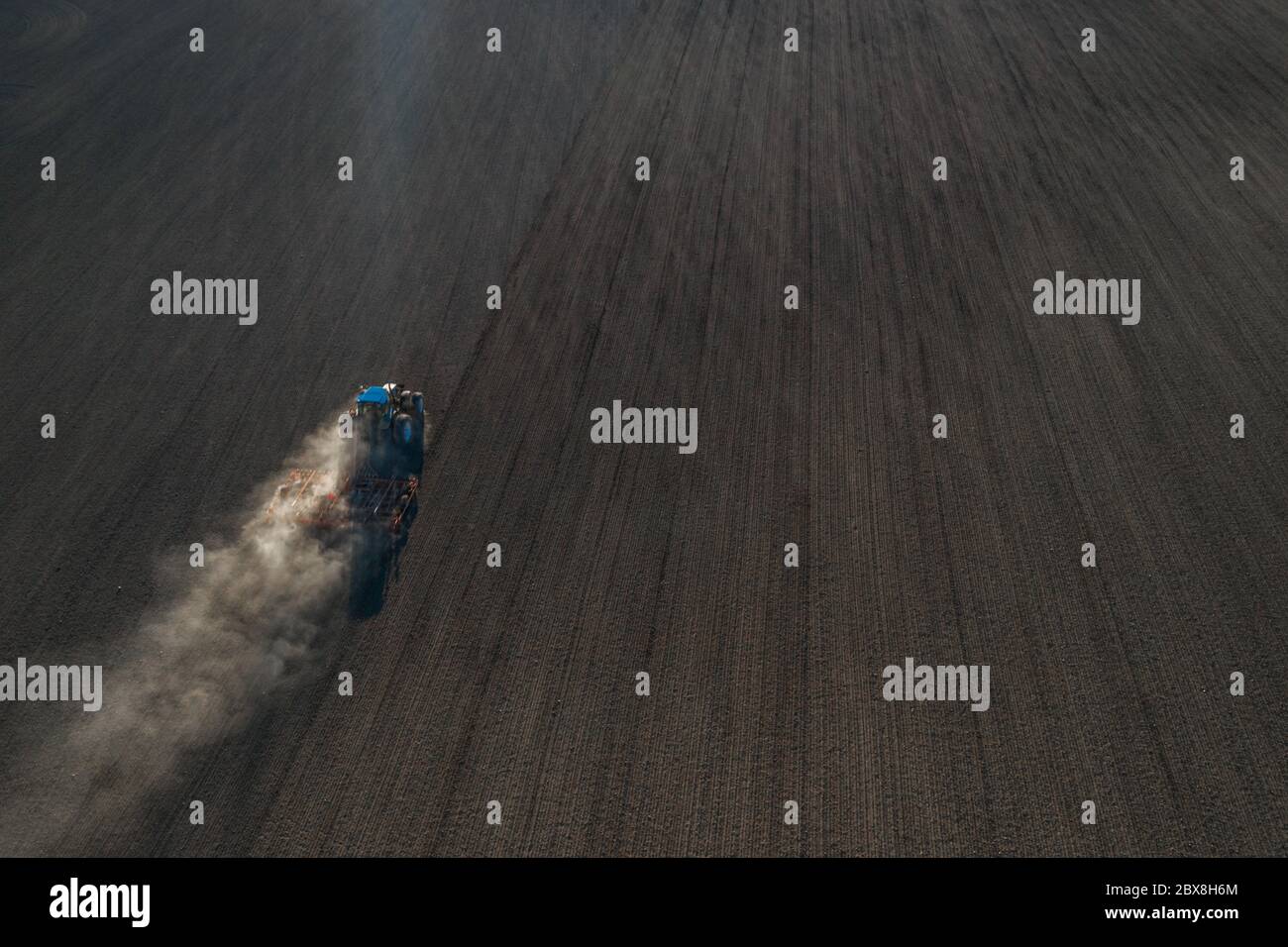 Vista aerea di un trattore che semina grano su un campo agricolo Foto Stock